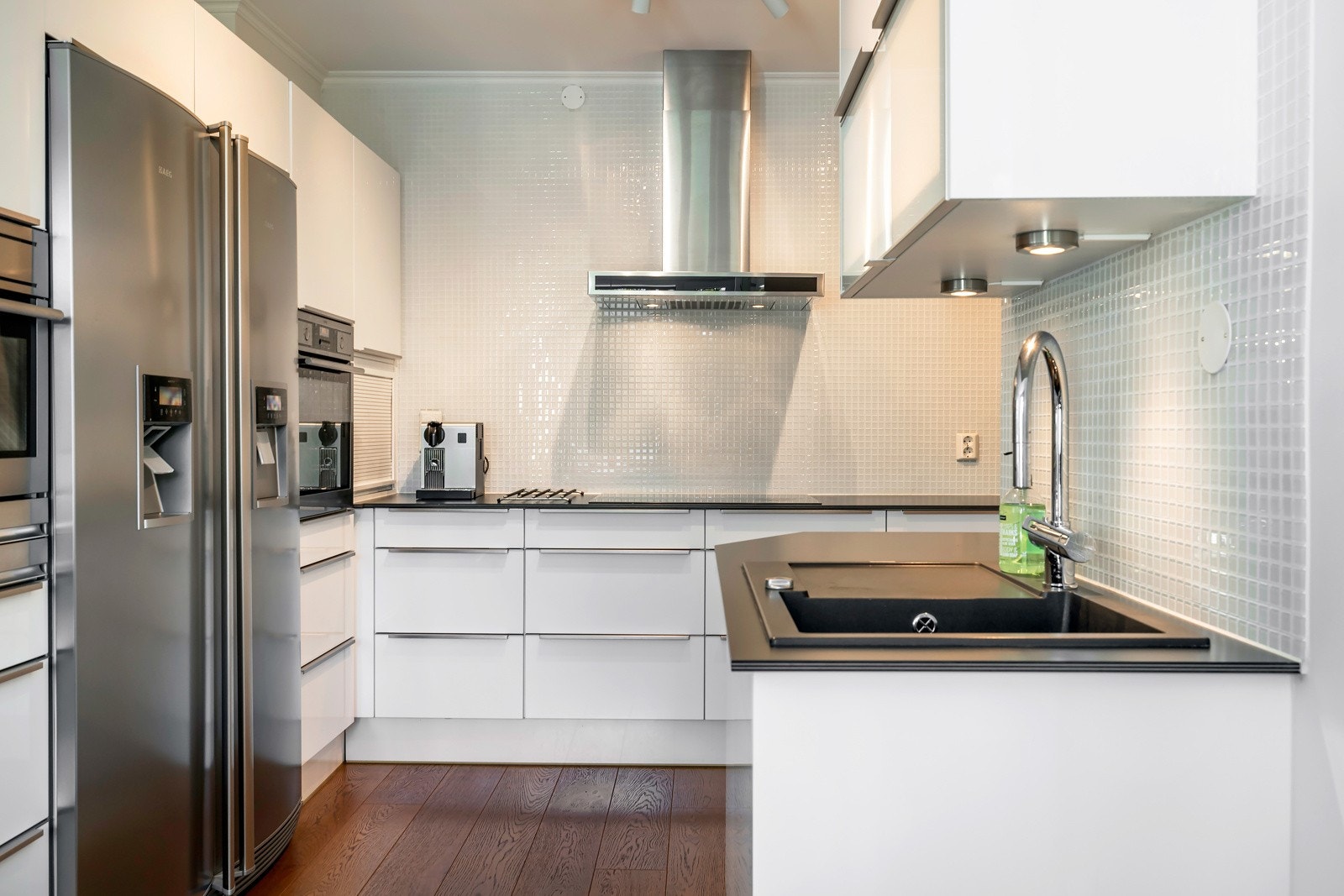 Boligen har et tiltalende kjøkken med spiseplass og nydelig utsyn. Innredningen er fra JKE Design og har en elegant og stilren utførelse med hvite fronter og benkeplate i laminat. Galleribilde