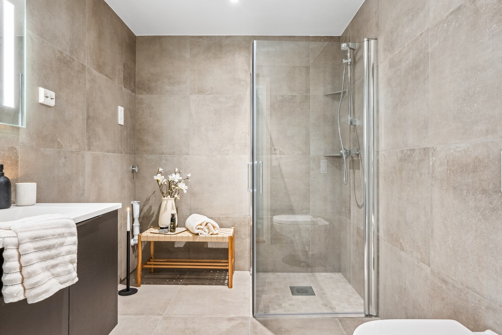 Flott bad med uttak med plassbesparende dusjvegger og opplegg for vaskemaskin. Galleribilde