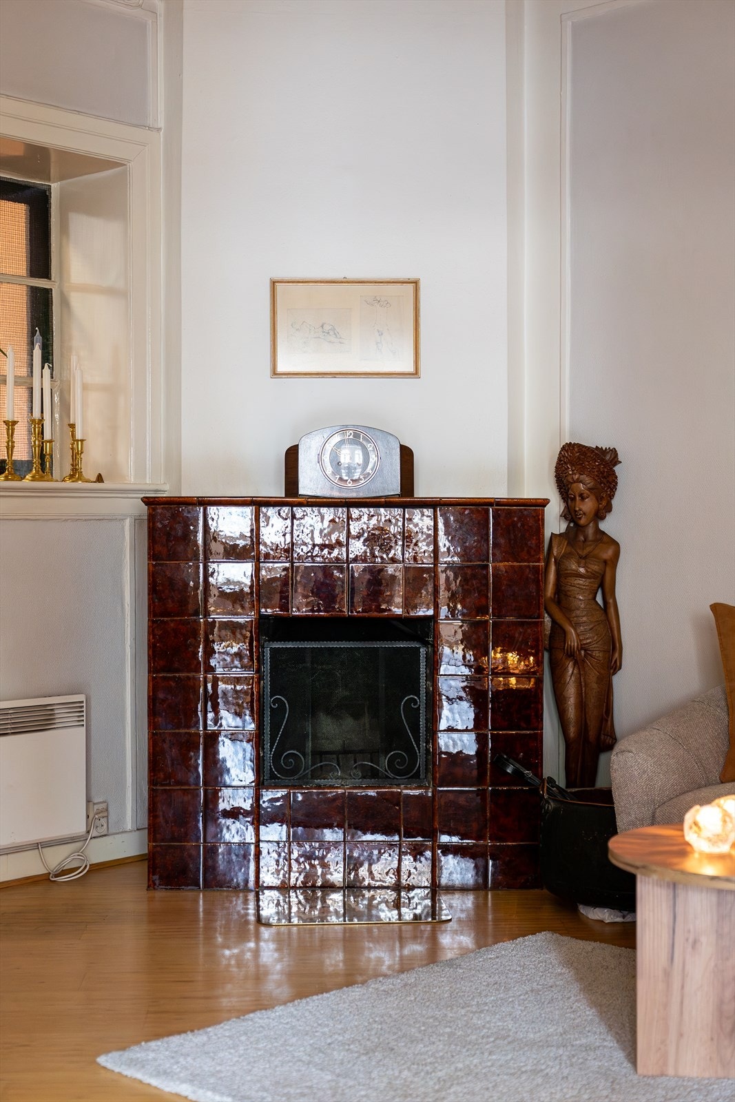 En praktfull, original kamin står som et elegant midtpunkt mellom stuene og tilfører rommet både karakter og varme. Galleribilde
