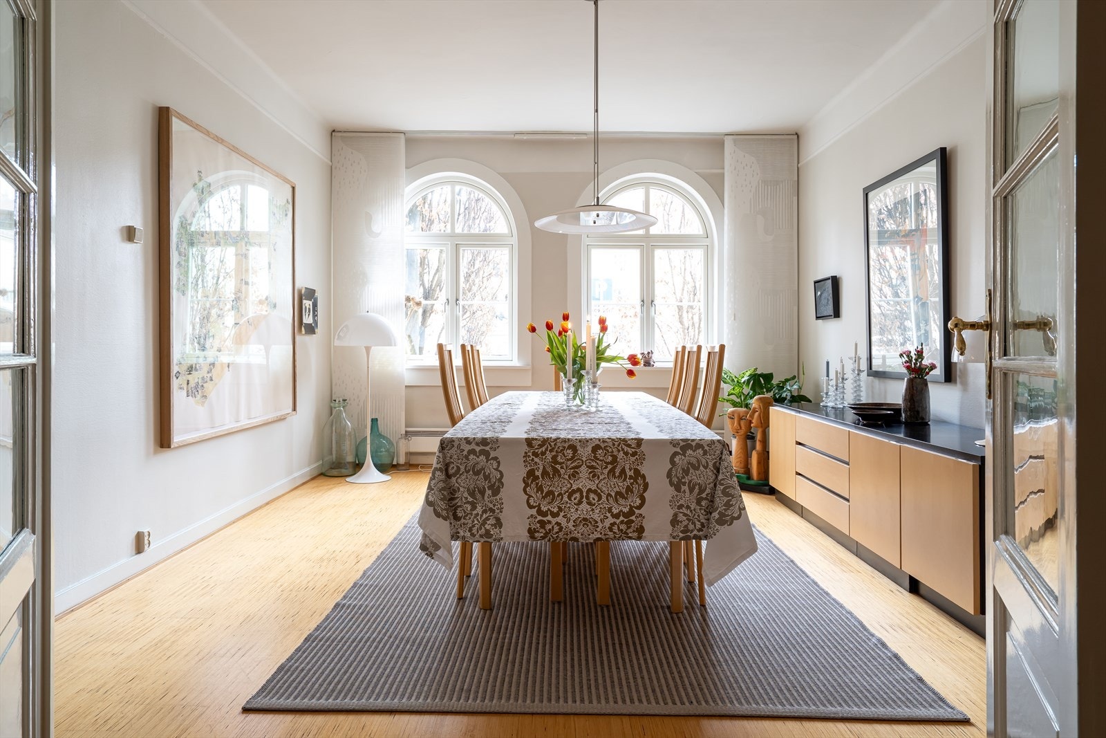 Spisestuen er et av leilighetens midtpunkter, med klassiske detaljer som de buede vinduene som slipper inn rikelig med naturlig lys. Galleribilde