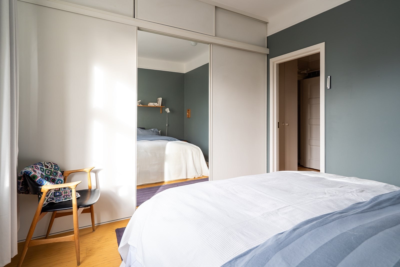 Det er etablert en praktisk skyvedørsgarderobe med speilfront i midten til oppbevaring. Galleribilde