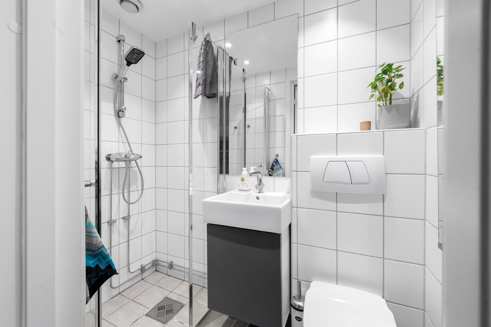 Badet er pent flislagt på gulv og vegger med varme i gulvet. Innredningen består av vegghengt servantinnredning med servant. Over servanten er det et fint speil. Galleribilde