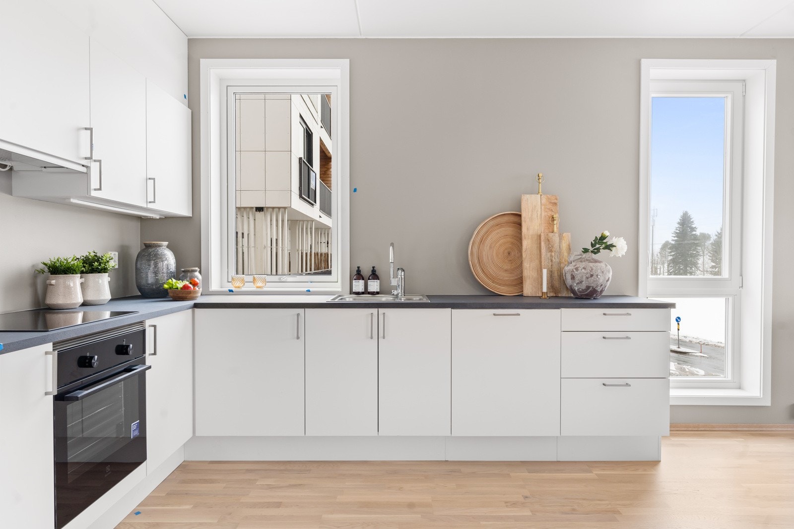 Kjøkkeninnredning leveres fra Sigdal, eller tilsvarende, med hvite glatte fronter. Laminat benkeplate med oppvaskkum i rustfritt stål og ettgreps blandebatteri. Bilde tatt fra lignende leilighet i prosjektet Galleribilde