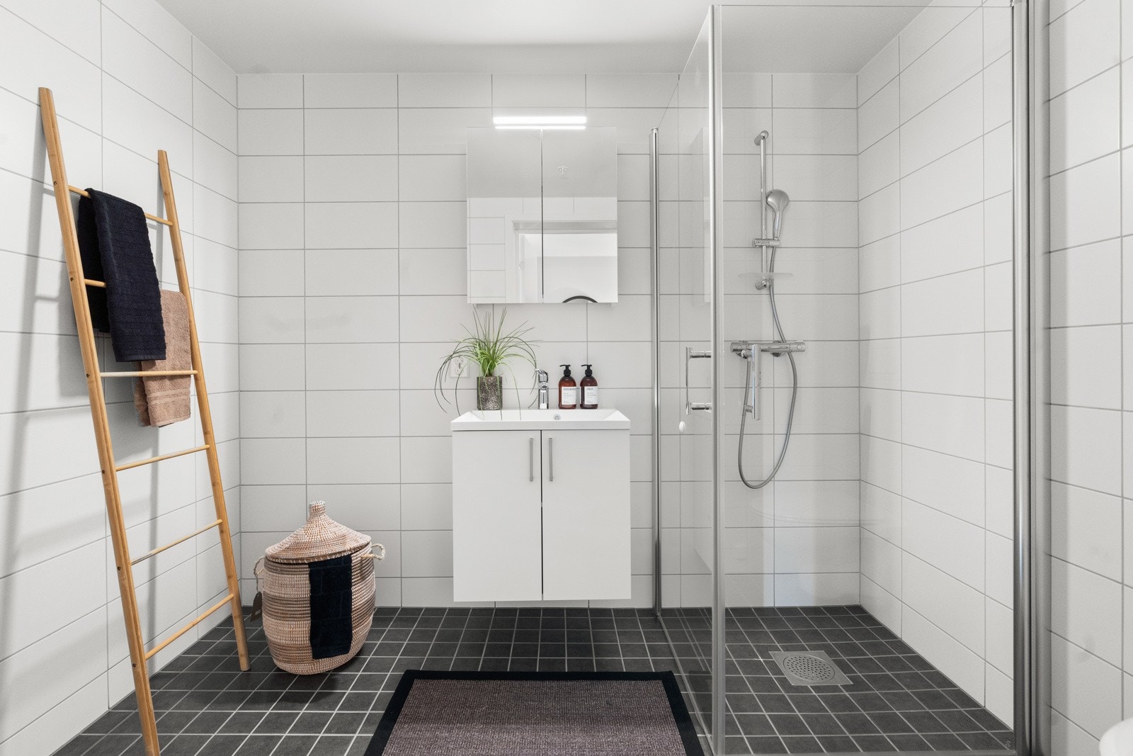 Flott flislagt bad. Videre leveres ettgreps dusjbatteri med dusjgarnityr (fleksibel slange og hånddusj) og dusjhjørne. Bilde tatt fra lignende leilighet i prosjektet Galleribilde