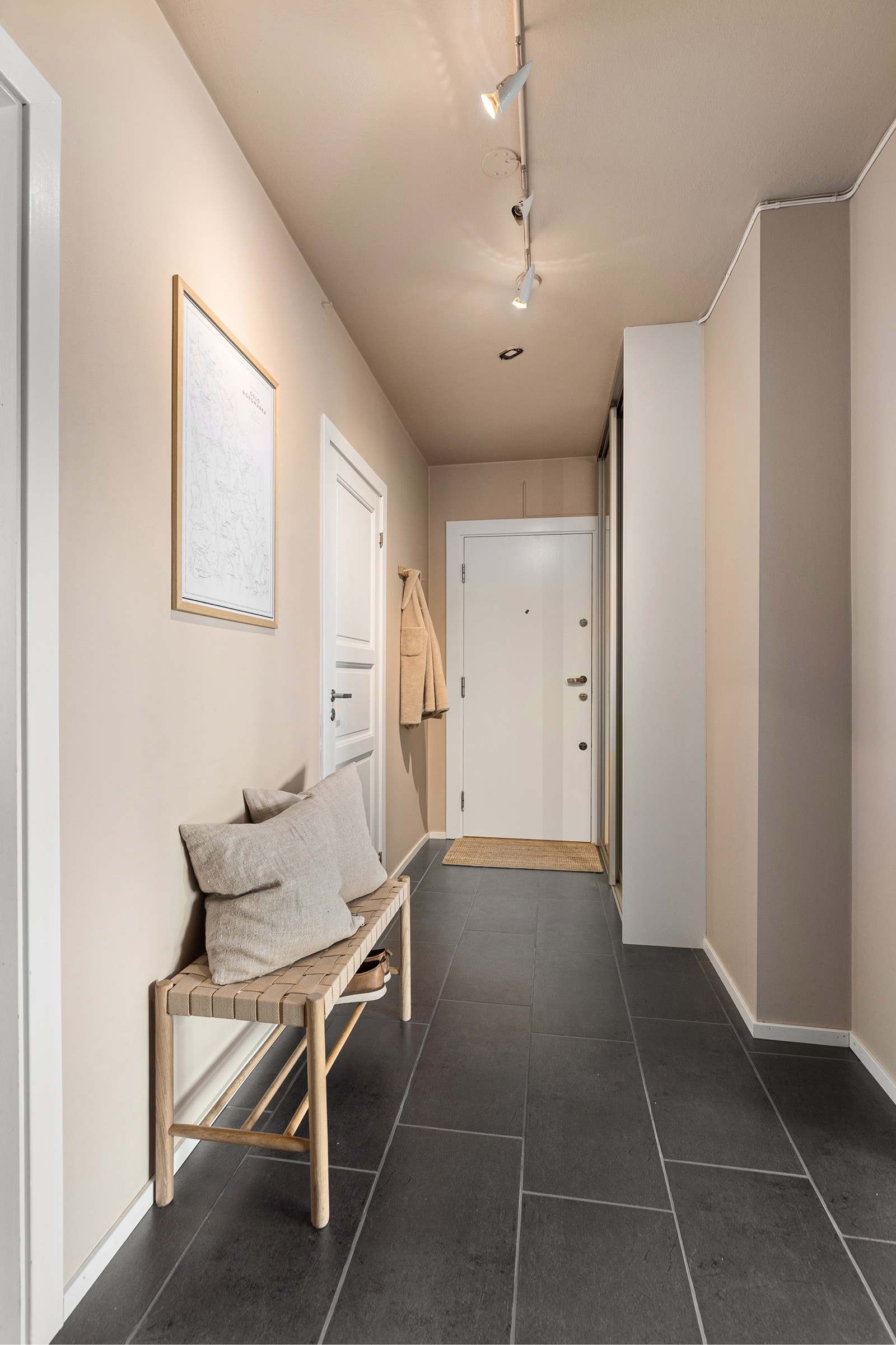 Entréen har flislagt gulv med varme og moderne fargevalg på veggene. Galleribilde