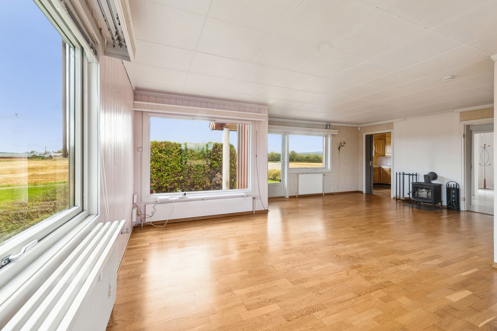Stor stue med god plass til spisestue og sofamøblering - mange vinduer som slipper lys inn. Galleribilde