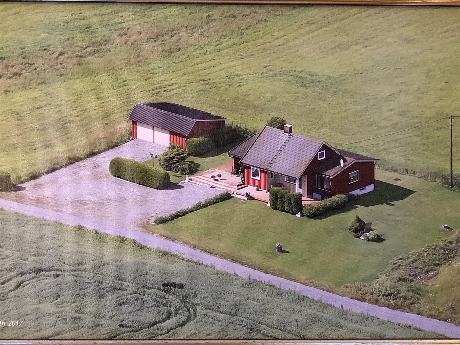 Her et flyfoto fra 2017 som viser et overblikk over eiendommen med tilgrensende landbruksarealer Galleribilde