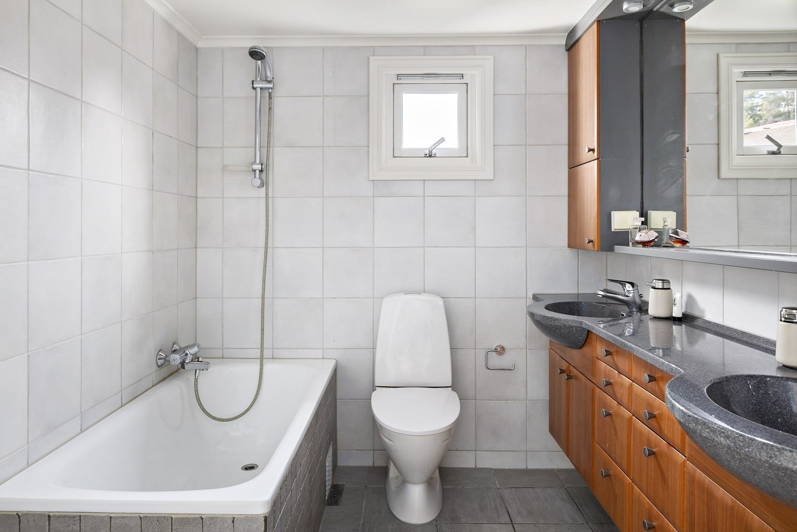 Baderom med flislagt gulv (30x30 cm) og vegger (25x25 cm), samt 7x7 cm mosaikkfliser rundt badekaret. Galleribilde