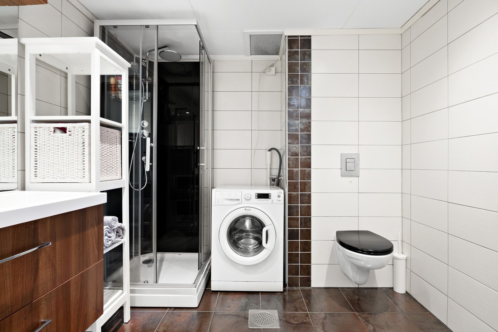 Badet har en god størrelse med plass til mye og det er opplegg for vaskemaskin. Det er flislagt på vegger og gulv med behagelig varme under beina Galleribilde