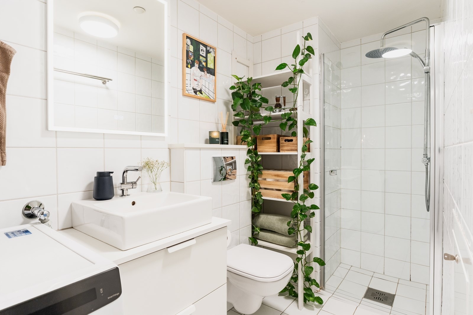 Tidløst og pent bad fra 2011 med flislagte vegger/gulv, slett himling og gulvvarme. Badet består av dusj, toalett og servant. Opplegg/plass til vaskemaskin. Galleribilde