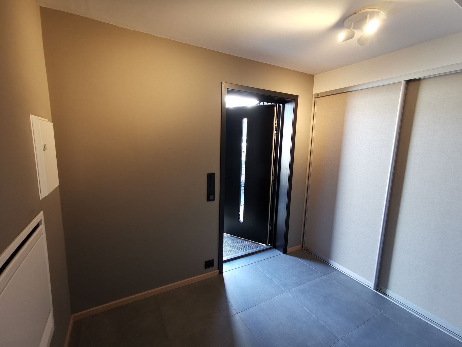 Entre sett fra kjøkken mot inngangsdør. Skyvedørsgarderobe på veggen til høyre. Galleribilde