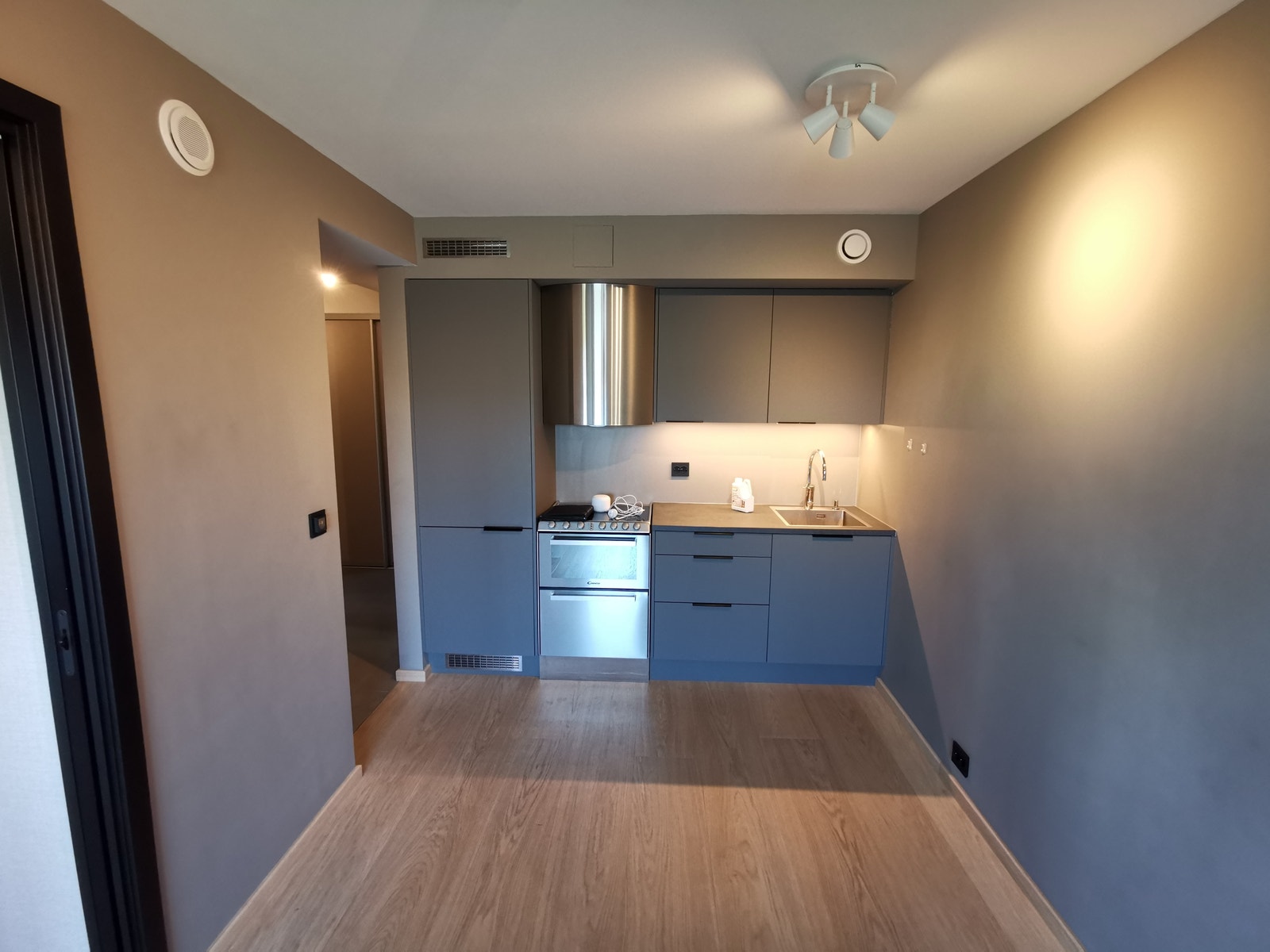 Kjøkken med kjøl/frys til venstre, komfyr med oppvaskmaskin, skuffeseksjon og uttrekkbar avfallssortering. Ventilator med kullfilter og 2 stk. overskap. Galleribilde