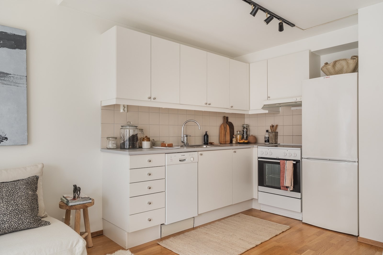 Fin kjøkkeninnredning med oppvaskmaskin, komfyr og kombinert kjøl- og fryseskap som medfølger Galleribilde