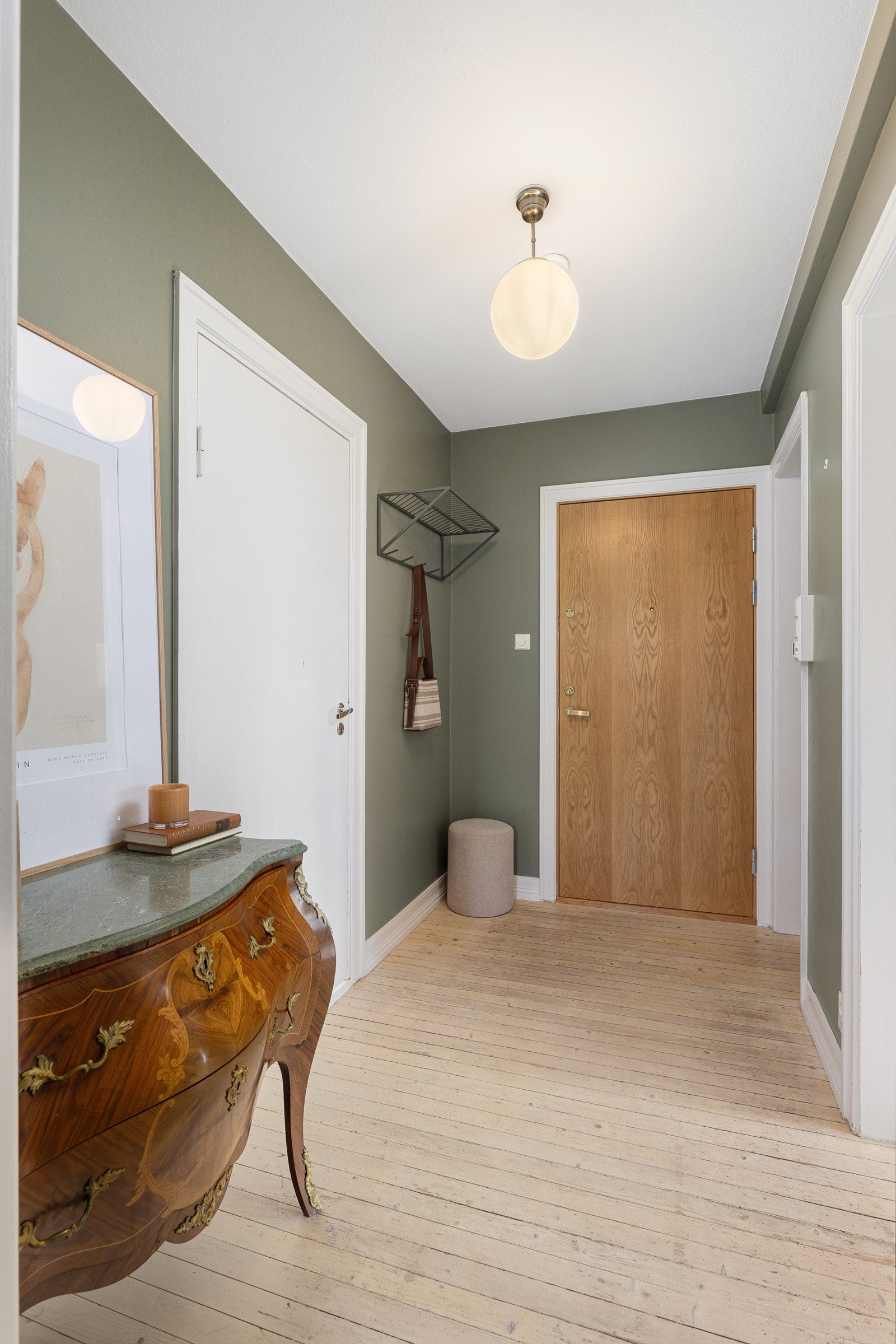 En lys og romslig entré med et klassisk gulv av heltre, og moderne malte overflater som gir et friskt og tidløst preg. Galleribilde