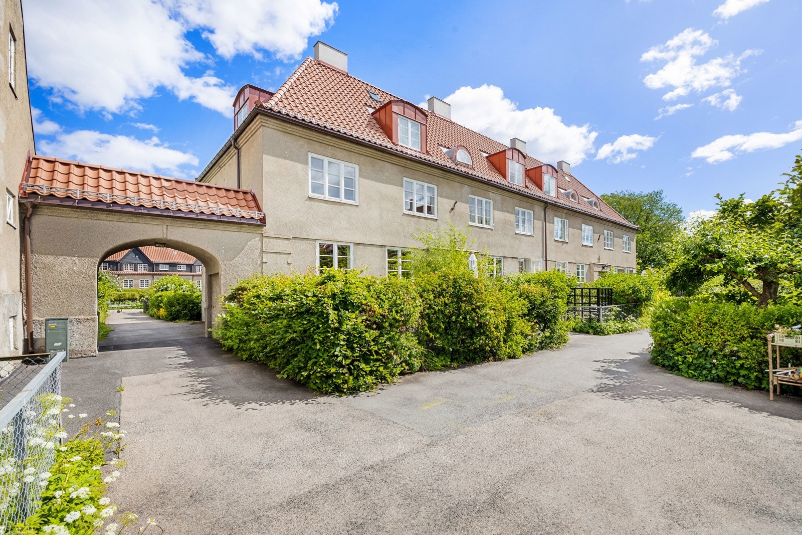 Via en asfaltert vei og buet port fra Langlia er det adkomst til en frodig, sjarmerende og sosial bakgård; rikelig med trygg boltreplass for barn i alle aldre. Galleribilde