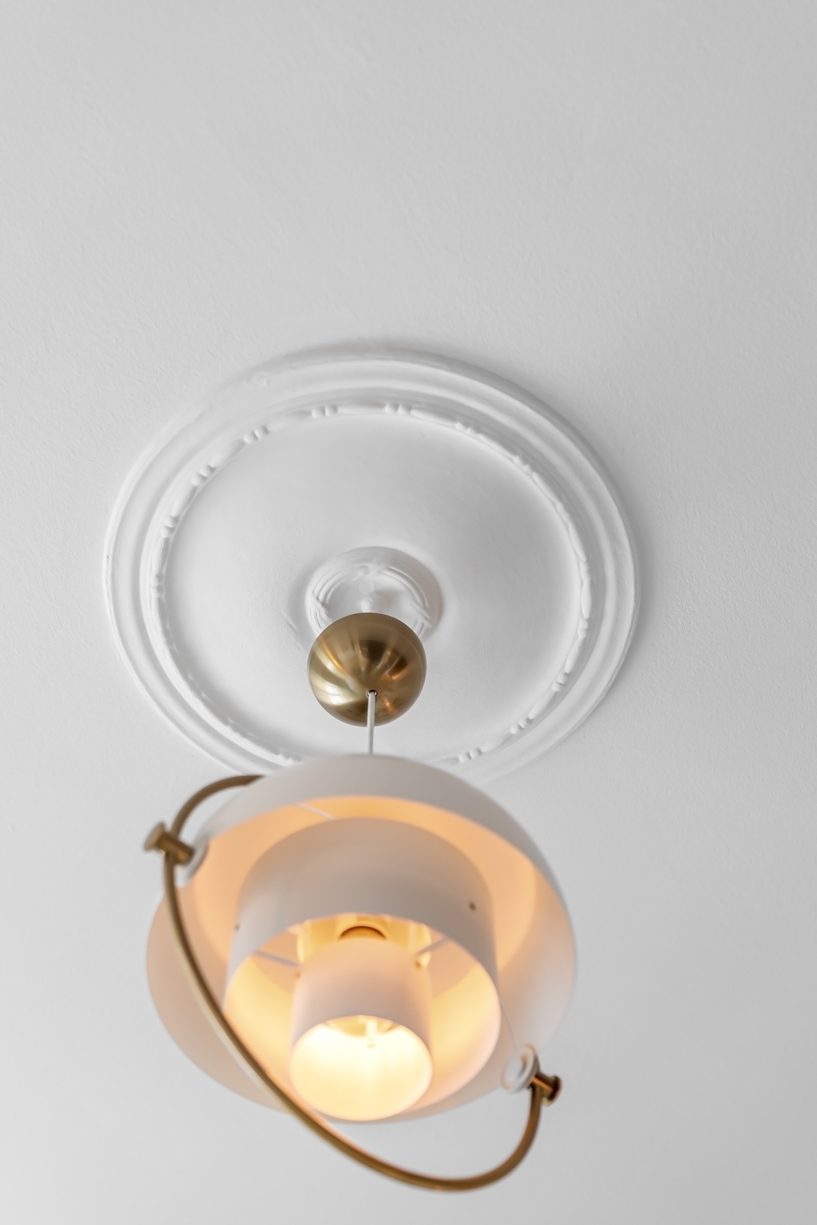 I den hvite himlingen er det to klassiske takrosetter, og det er montert belysning i form av moderne designlamper. Galleribilde