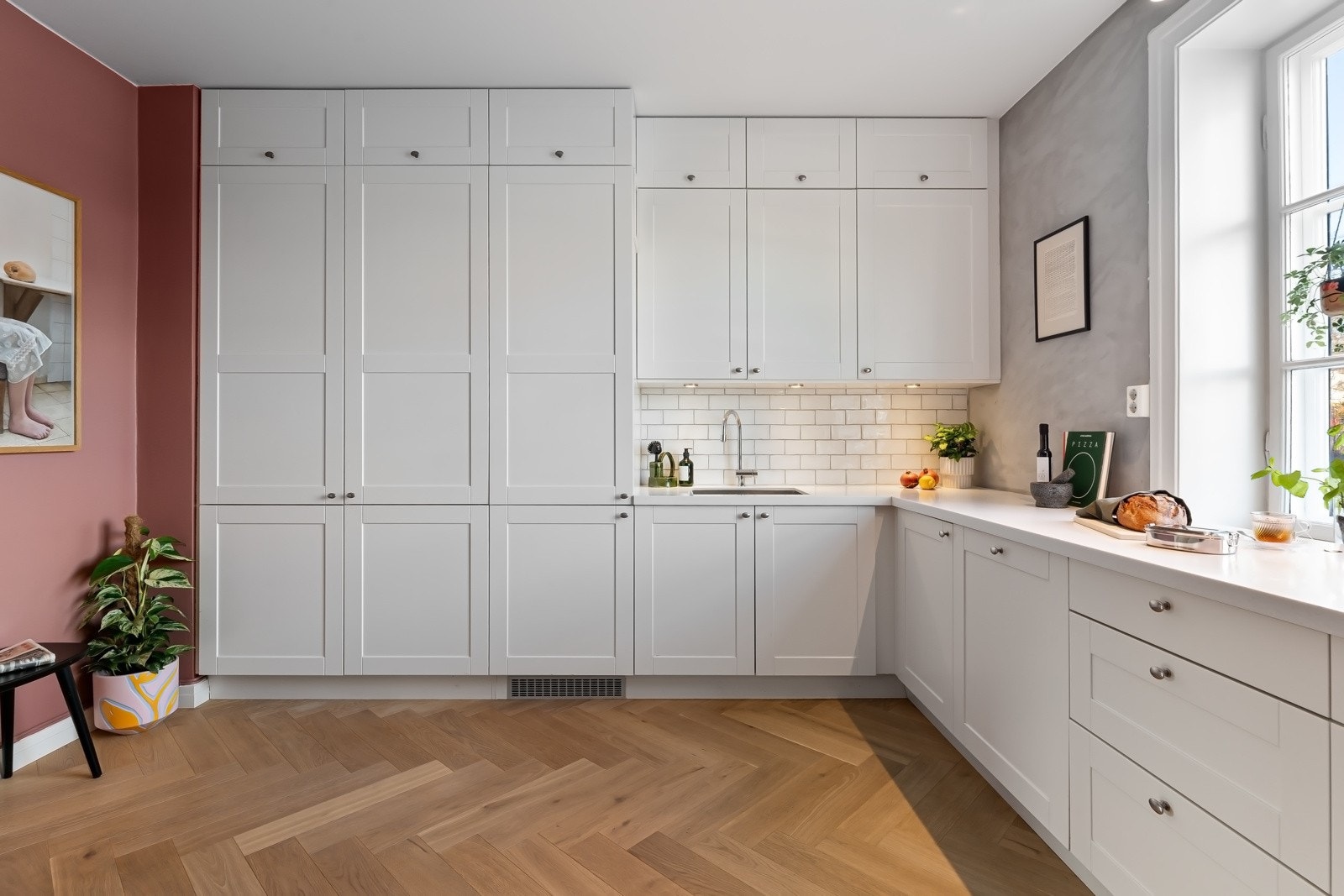 Innredningen fra HTH har hvite, profilerte fronter, takhøye skap og hvit benkeplate i corian med underlimt kum i stål. Galleribilde