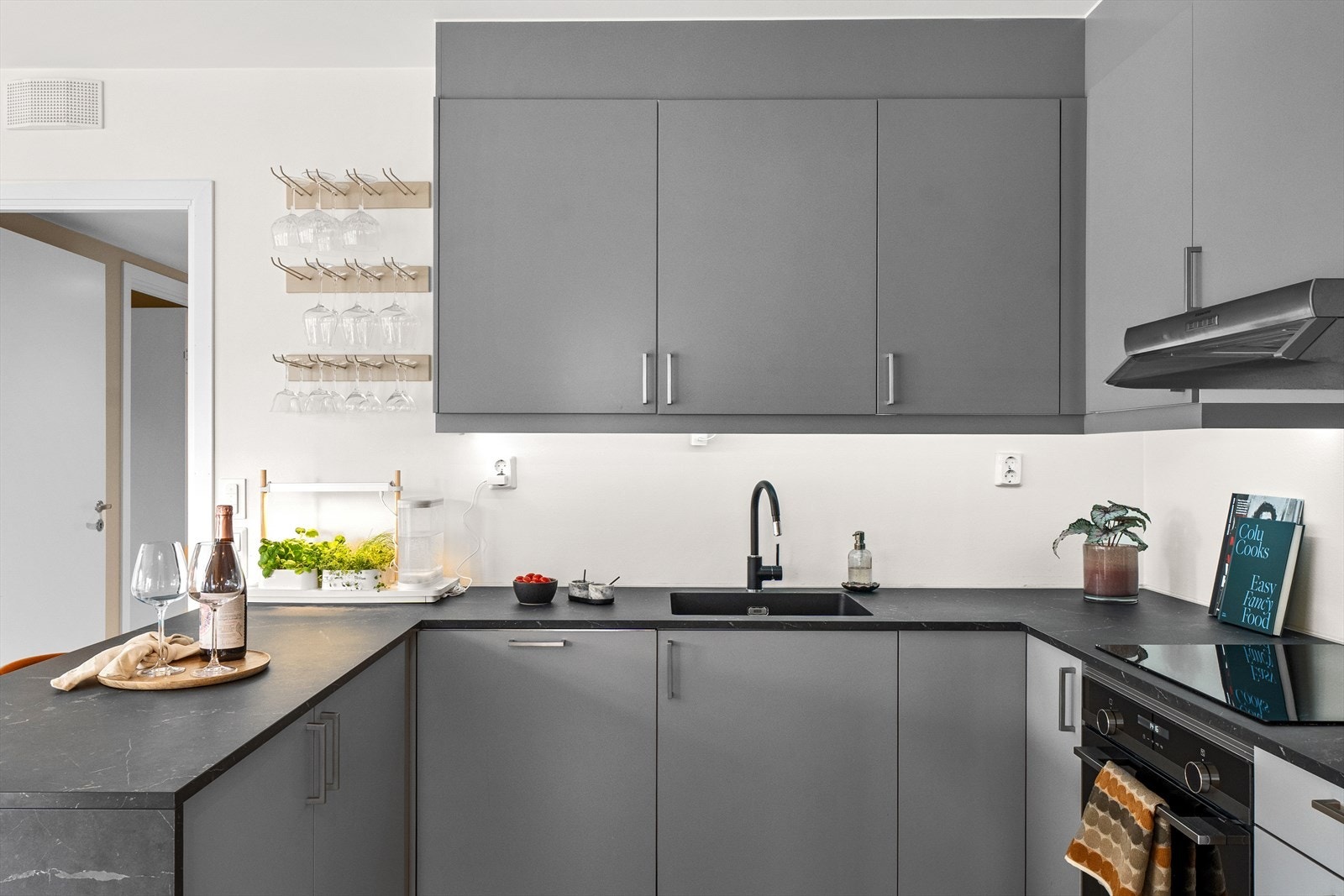 Moderne kjøkken med glatte fronter i både over- og underskap. Galleribilde