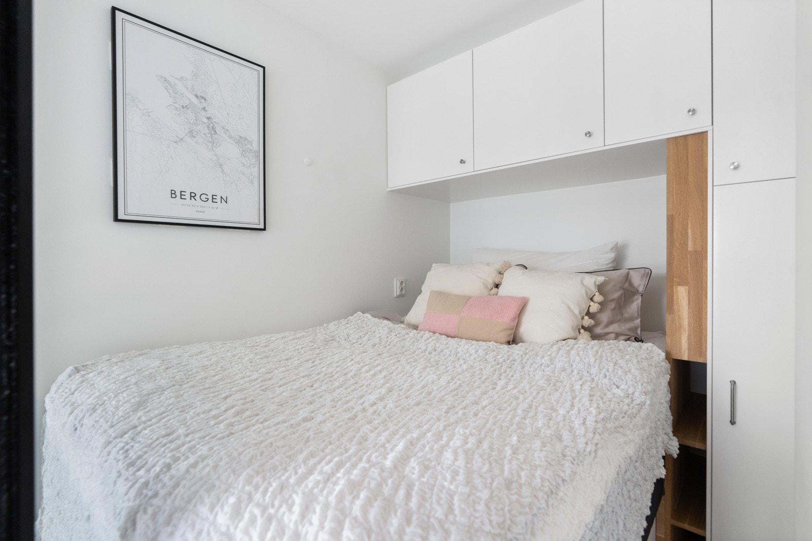 Plassbygget seng (140cm) med plassbygde garderobeskap og smarte hyller rundt. Det er også skuffer under sengen. Galleribilde