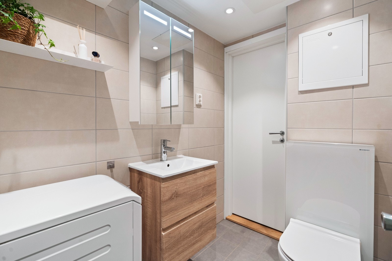 Badet består av vegghengt toalett, servant og servantskap, dusjhjørne med to foldbare glassdører og opplegg for vaskemaskin. Badet har fortsatt garanti. Galleribilde