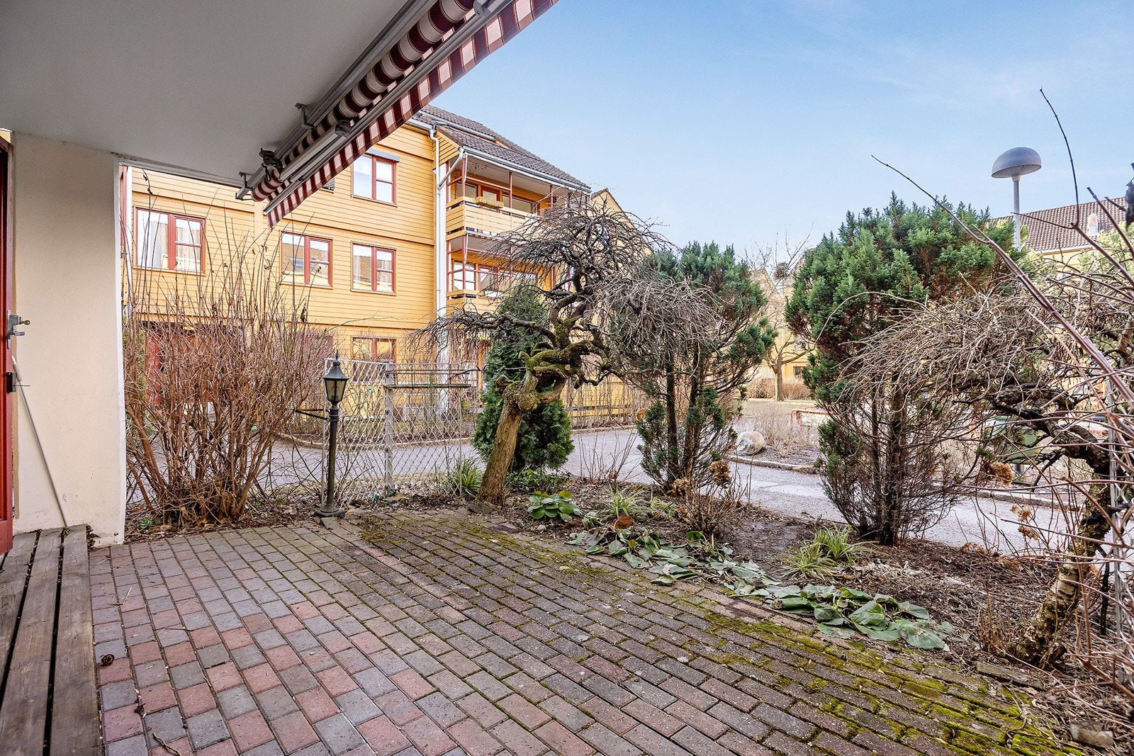 Terrassen er hellebelagt og har elektrisk markise. Terrassen vender mot bilfritt tun som er pent opparbeidet med grønrarealer, lekeplasser og sittegrupper. Galleribilde