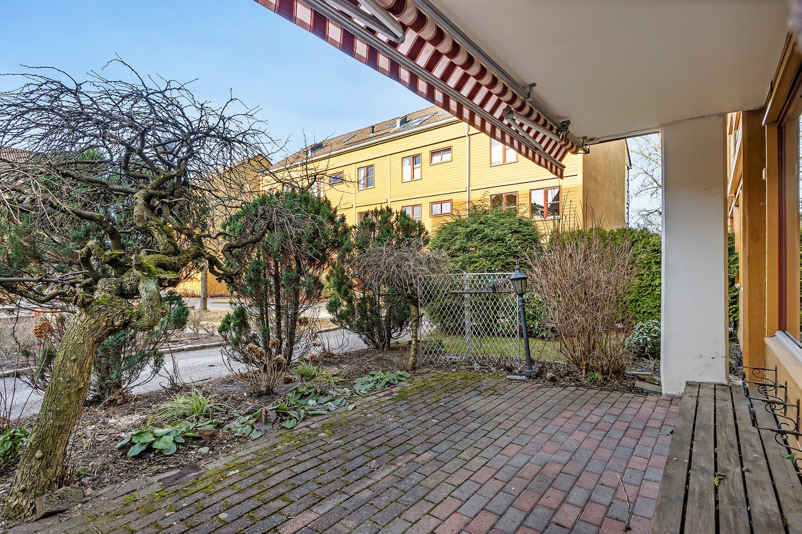 Stor vestvendt markterrasse på 13 kvm. omkranset av busker og beplantning. Galleribilde