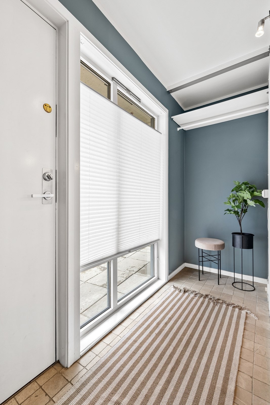 Velkommen inn! I vindfanget er flislagt gulv med elektriske varmekabler og fastmontert hylle og stang for oppheng av yttertøy. Galleribilde