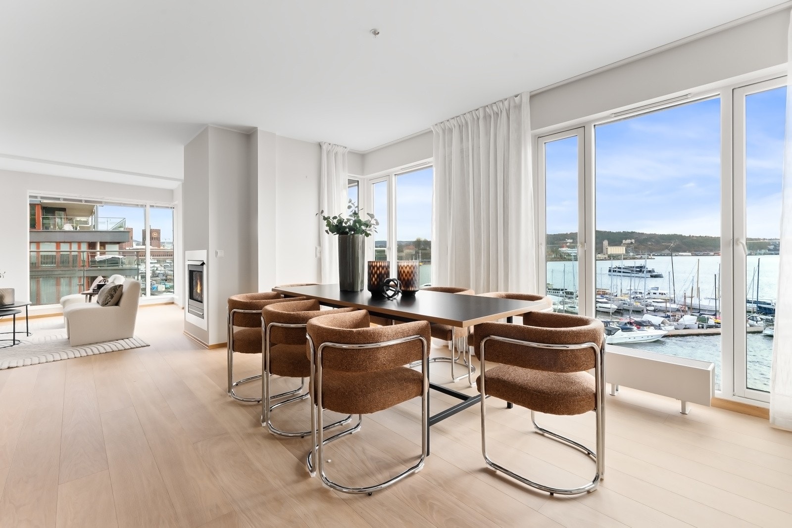 Stuen er et fantastisk rom der store panoramavinduer drar sjøutsikten godt inn fra to sider og nærmest visker ut skillet mellom ute og inne. Galleribilde