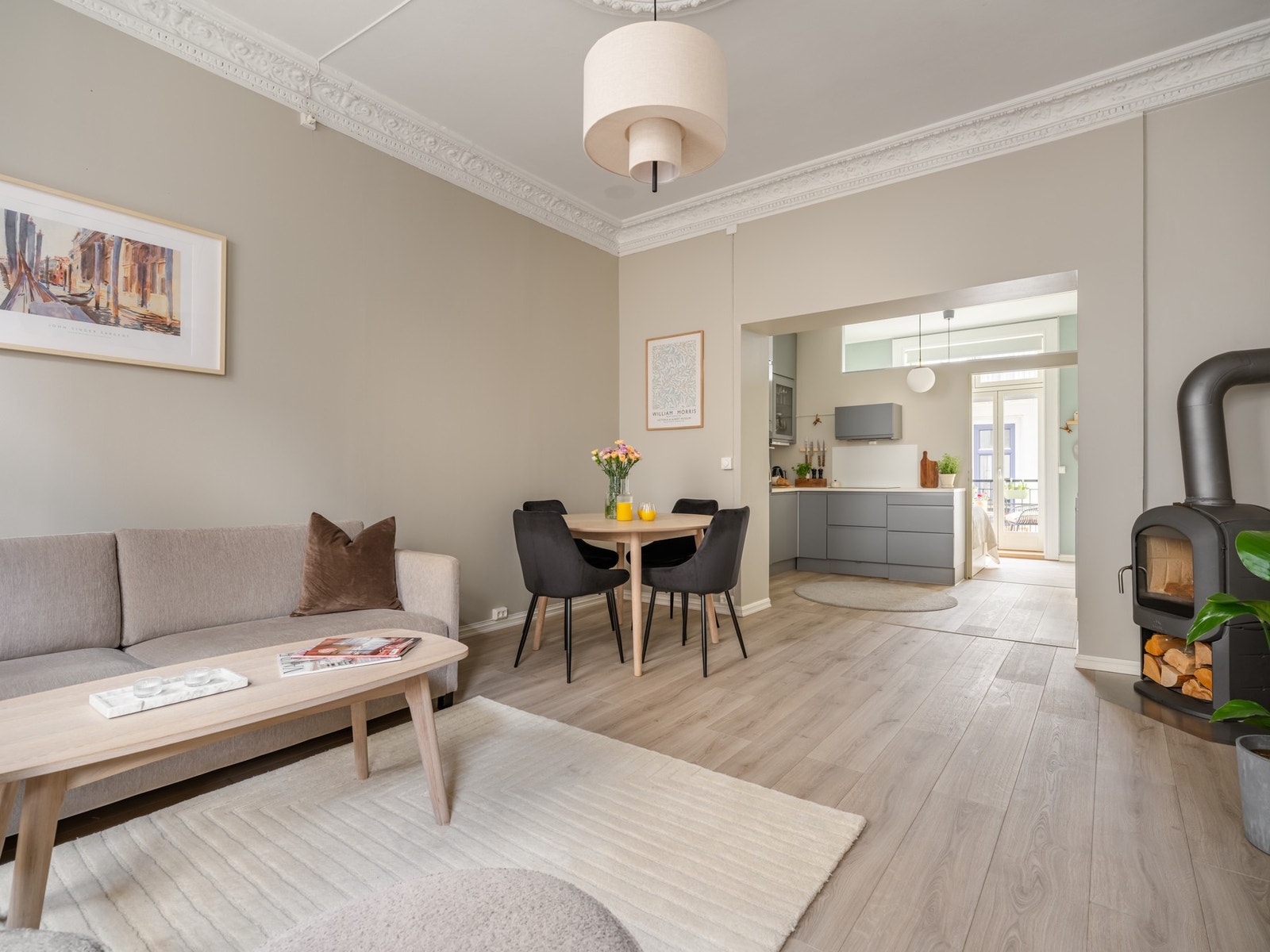 Stor åpning mellom stue og kjøkken lager et nydelig gjennomlys i leiligheten. Galleribilde