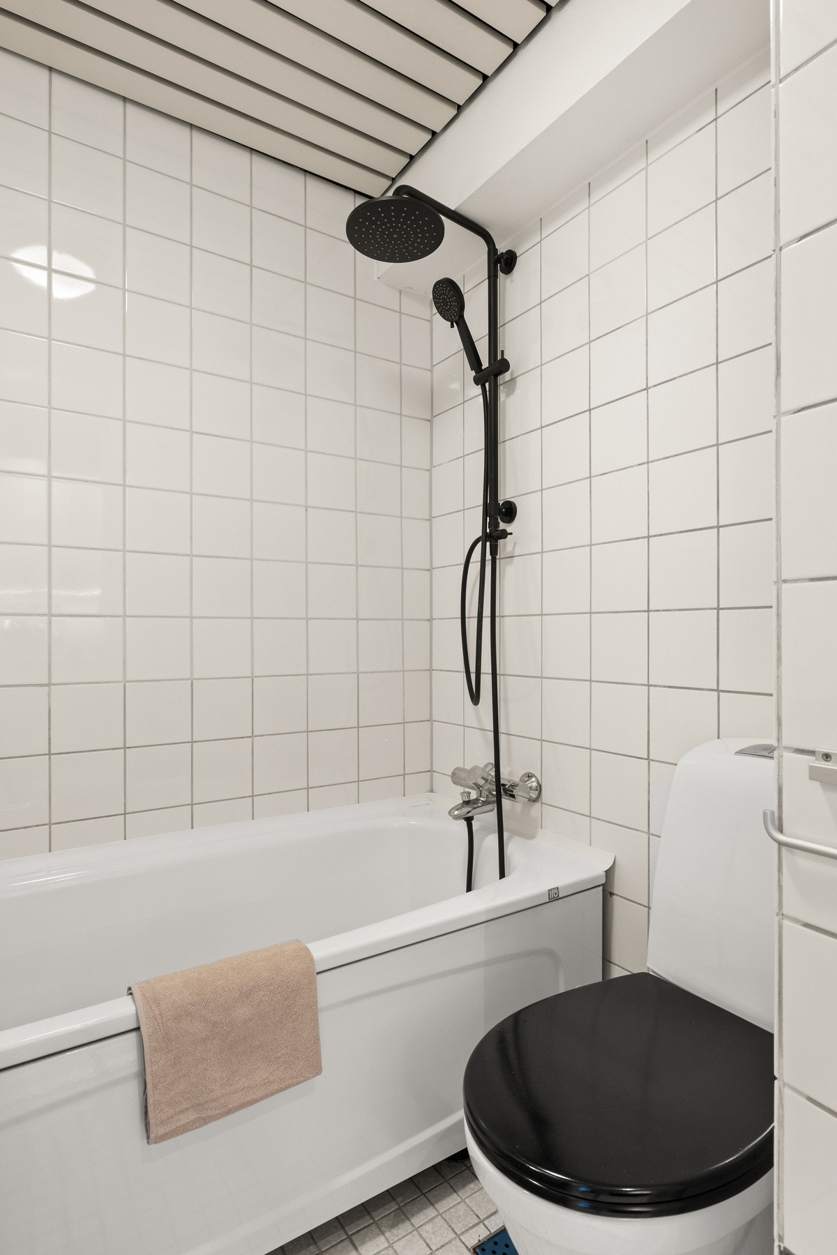 Badekar med dusjarmatur tilkoblet hånddusj og regndusj. Galleribilde