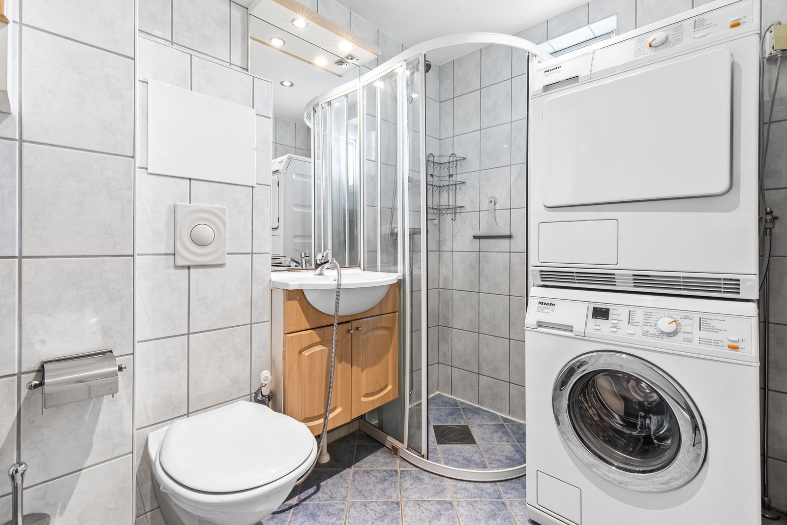 Det er opplegg for vaskemaskin og dusjkabinett med to dører. Galleribilde