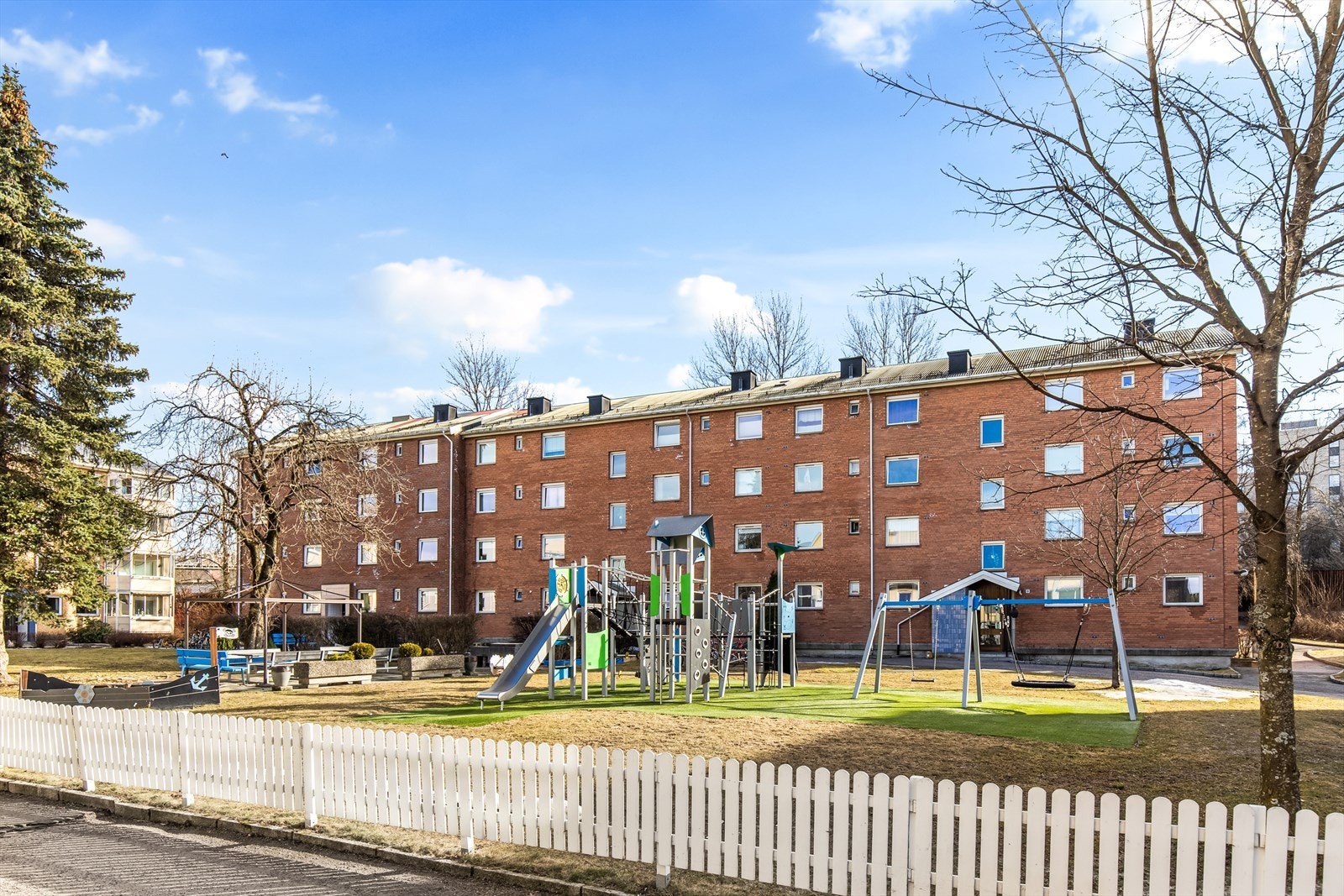 Koselig fellesområder med lekeplass for barna og sittegrupper for de voksne. Galleribilde