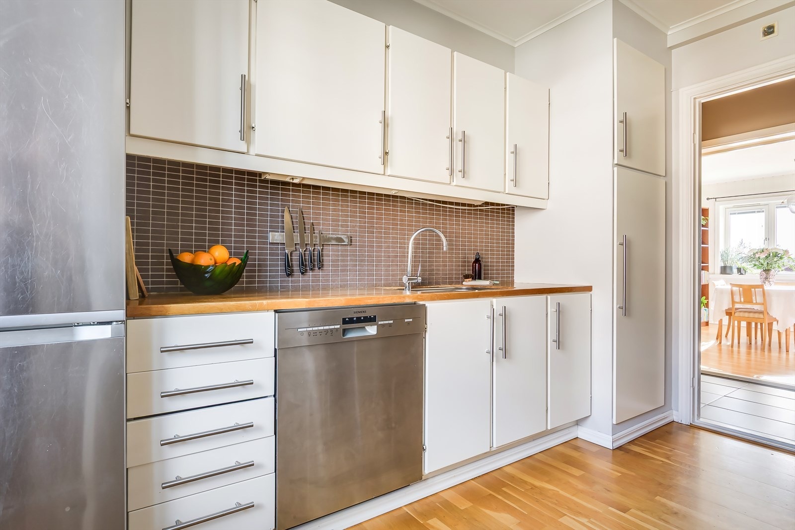 Kjøkkenet er utstyrt med hvitevarer som kjøl/fryseskap, oppvaskmaskin og komfyr med kullfiltervifte over Galleribilde