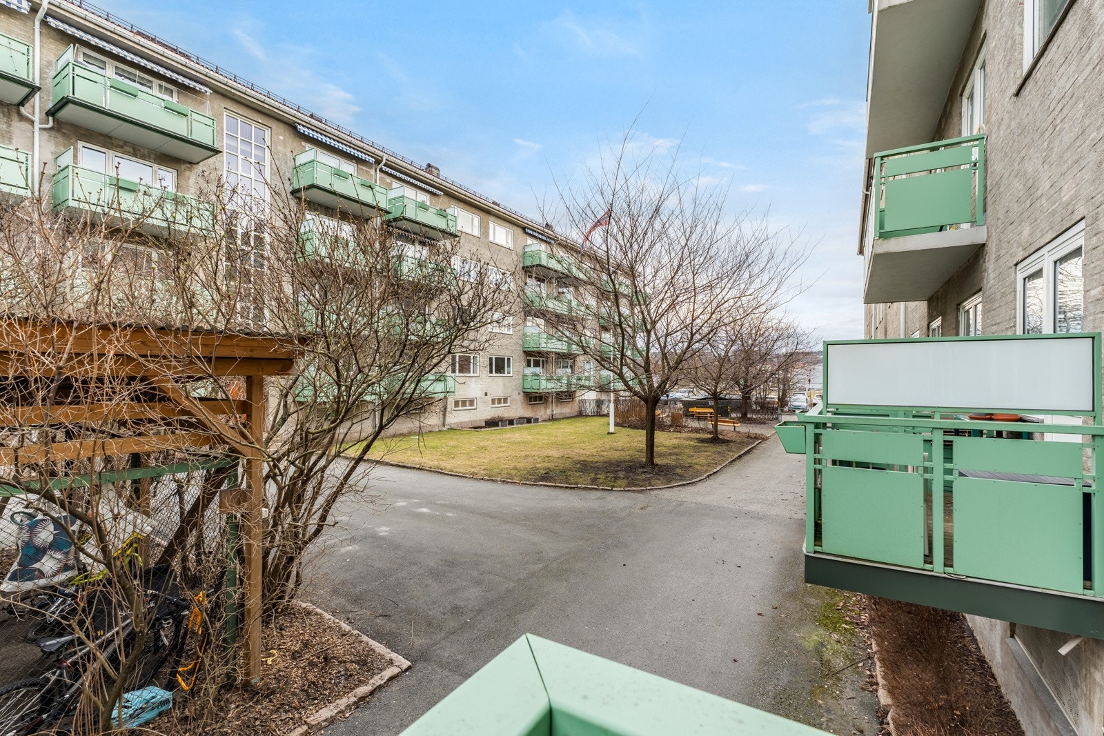 Fellesområder med sykkelparkering, sittegrupper og grønne plener. Galleribilde