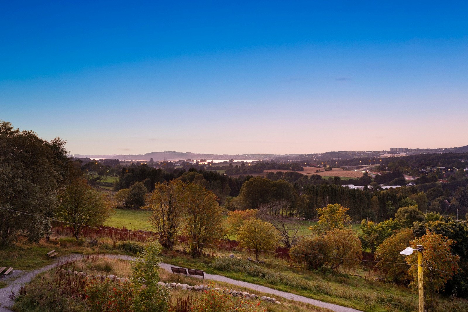 Utenfor stuen har leiligheten en herlig terrasse på hjørnet, med fantastisk panoramautsikt mot by, fjord, fjell og grønnkledde åser. Galleribilde