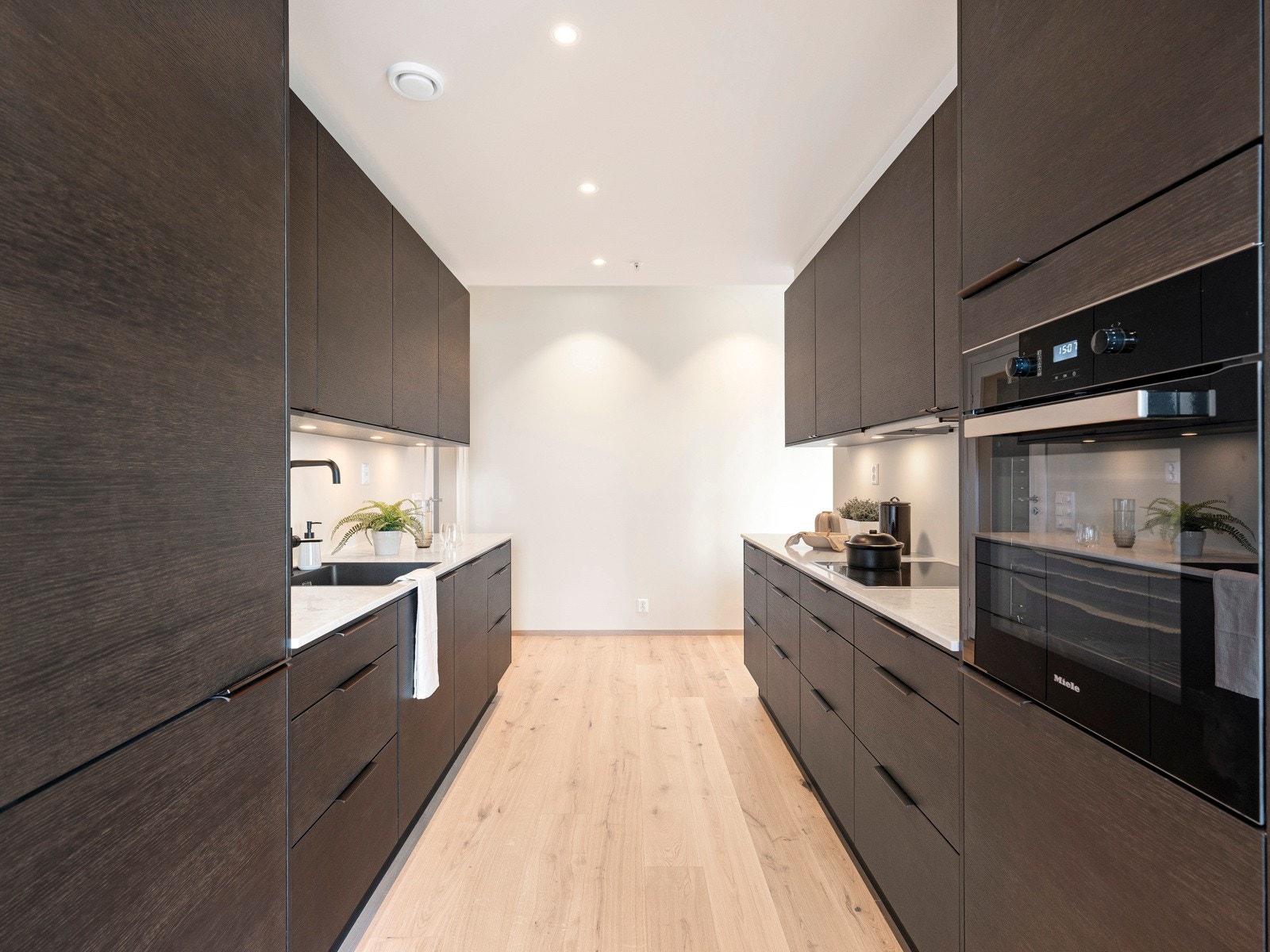 Hvitevarer fra Miele er integrert, bestående av induksjonstopp, oppvaskmaskin, en kombinert kjøl/frys og en stekeovn i høyskap med pyrolyse. Galleribilde