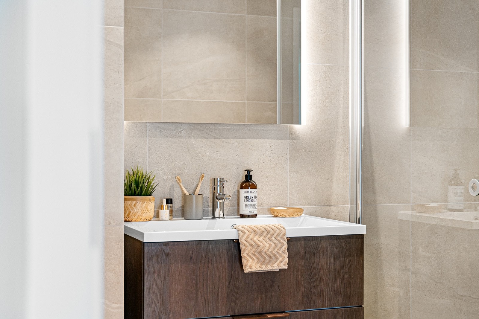 En kvalitetsinnredning fra Sigdal er valgt, bestående av servant med mørke skuffer og et speil med bakenforliggende belysning. Galleribilde