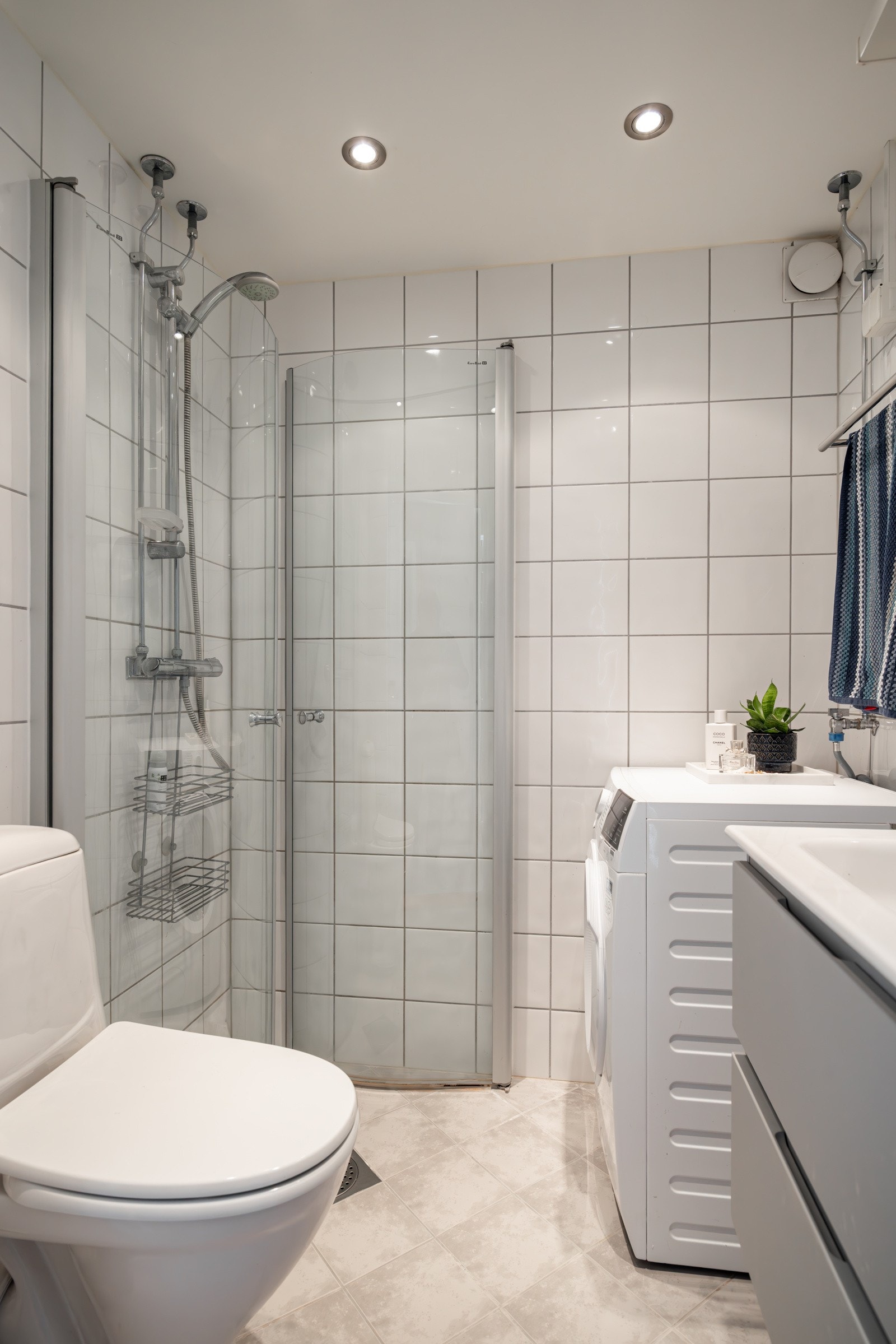 Leilighetens bad er pent oppusset i regi av borettslaget. Himlingen er senket med downlights, gulvet er flislagt med varme og veggene har lyse fliser. Galleribilde