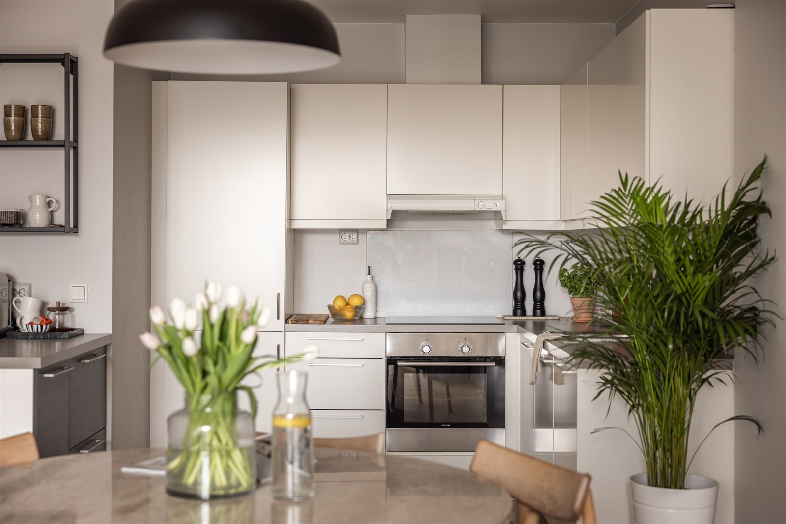 En hvit, glatt kjøkkeninnredning med benkeplate av laminat. Galleribilde