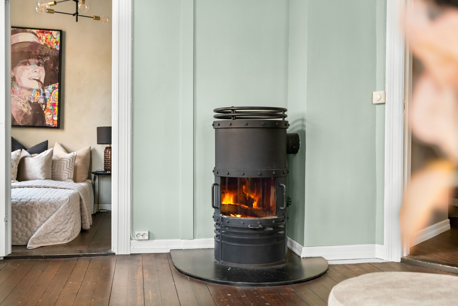 En sjarmerende vedovn tilfører både varme og hygge i vintermånedene. I tillegg til vedfyring varmes leiligheten opp med frittstående ovner og gulvvarme på bad. Galleribilde