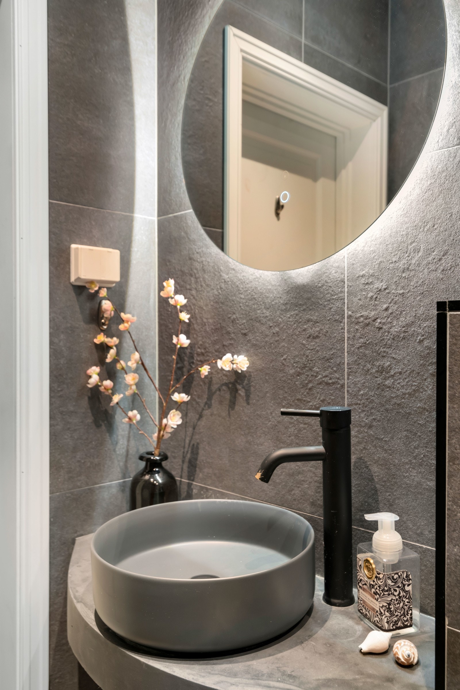 Eksklusiv plassbygget servantinnredning med overliggende servant og speil med integrert belysning gir badet et moderne preg. Galleribilde