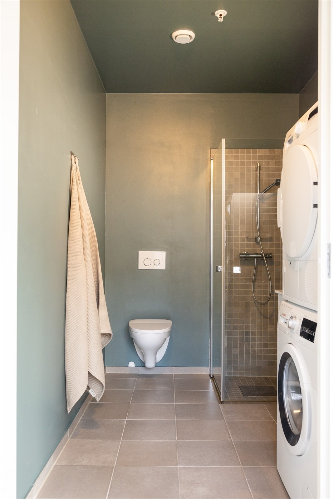 Det er fliser på gulv samt. vegger i dusjsone, og malte vegger ellers. Galleribilde