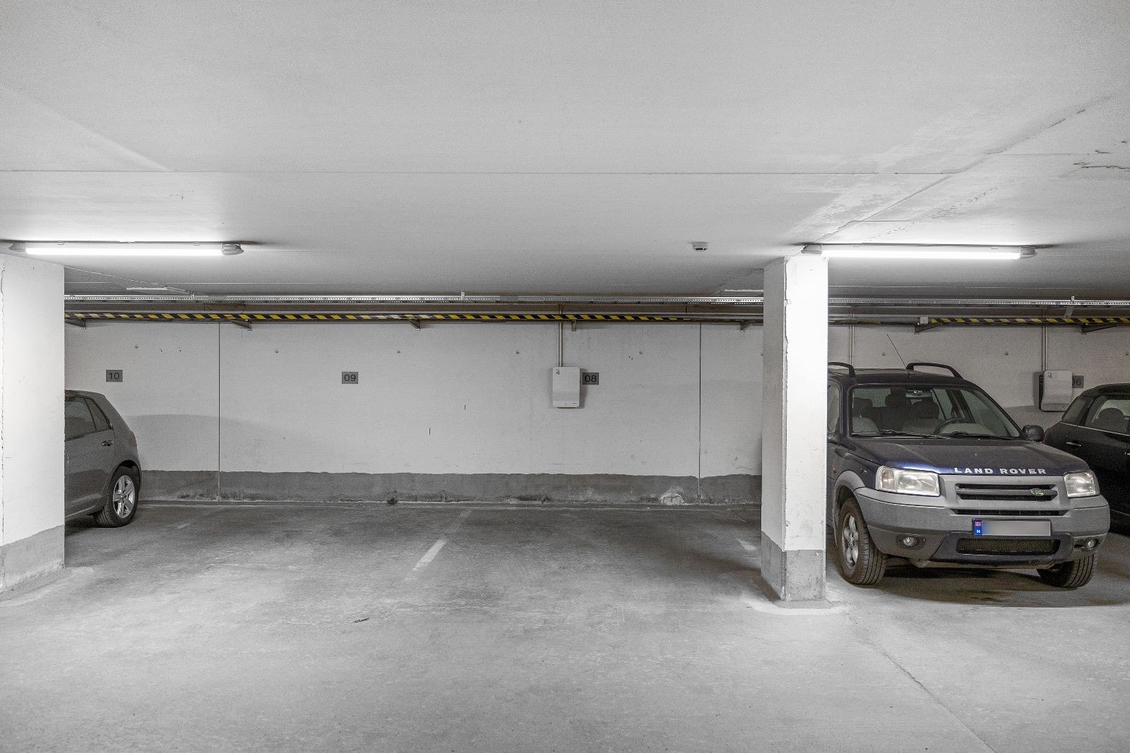 Parkeringsplass i garasjekjeller med EL-bil lader Galleribilde