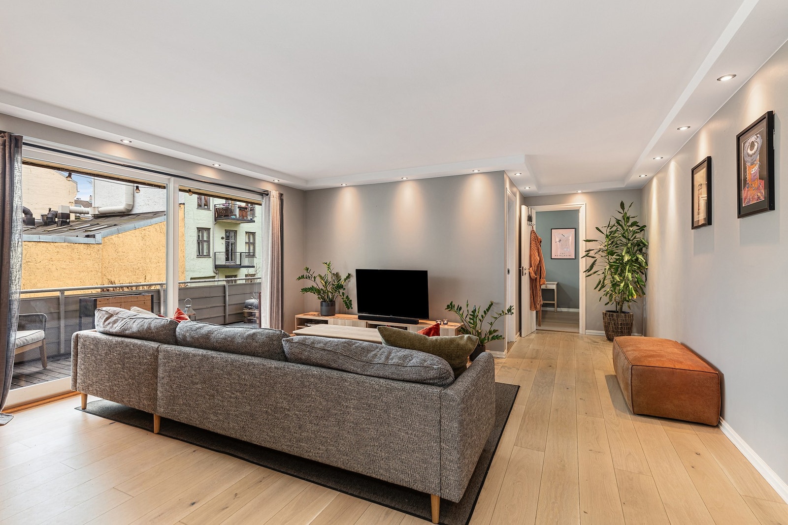 Stuen får mye naturlig lys fra vinduer og balkongdør satt inn i 2017. Galleribilde