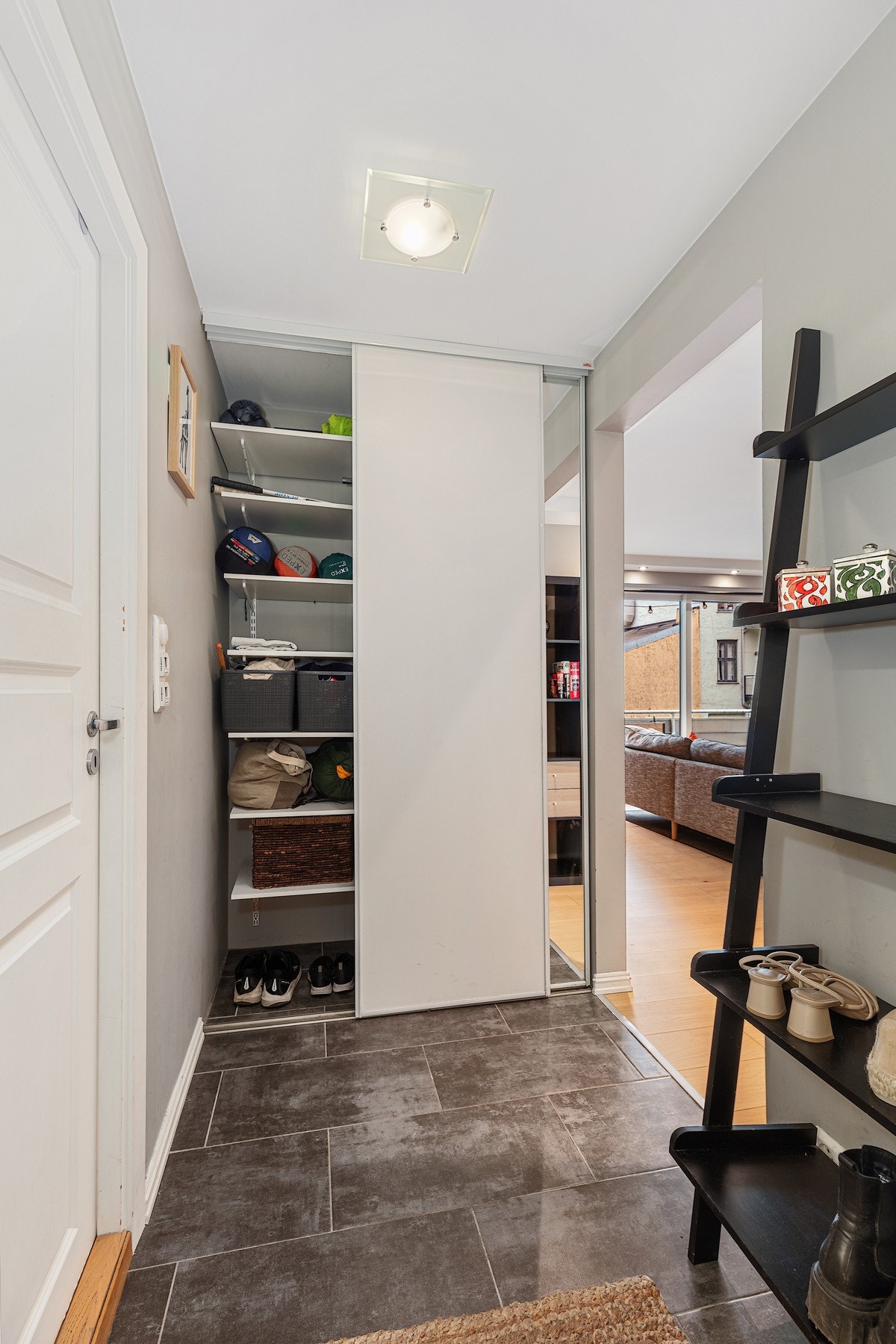 Leiligheten har praktisk entre med skyvedørsgarderobe og varmekabler på gulv. Galleribilde