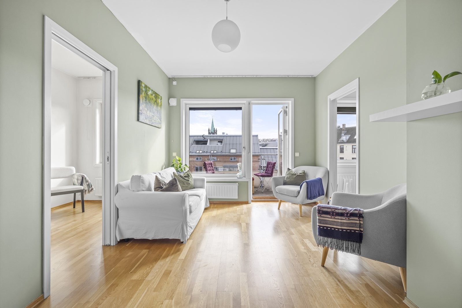 Stue i lekre farger og med store vindusflater som gir rommet mye naturlig lys Galleribilde