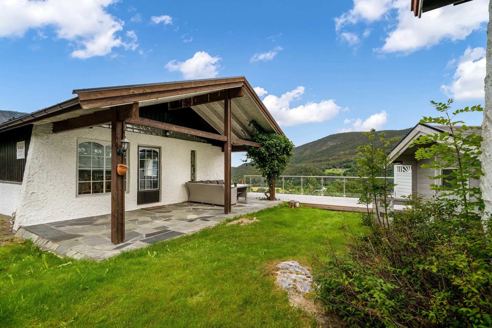 Fin uteplass og opparbeidet plen og planter. Galleribilde