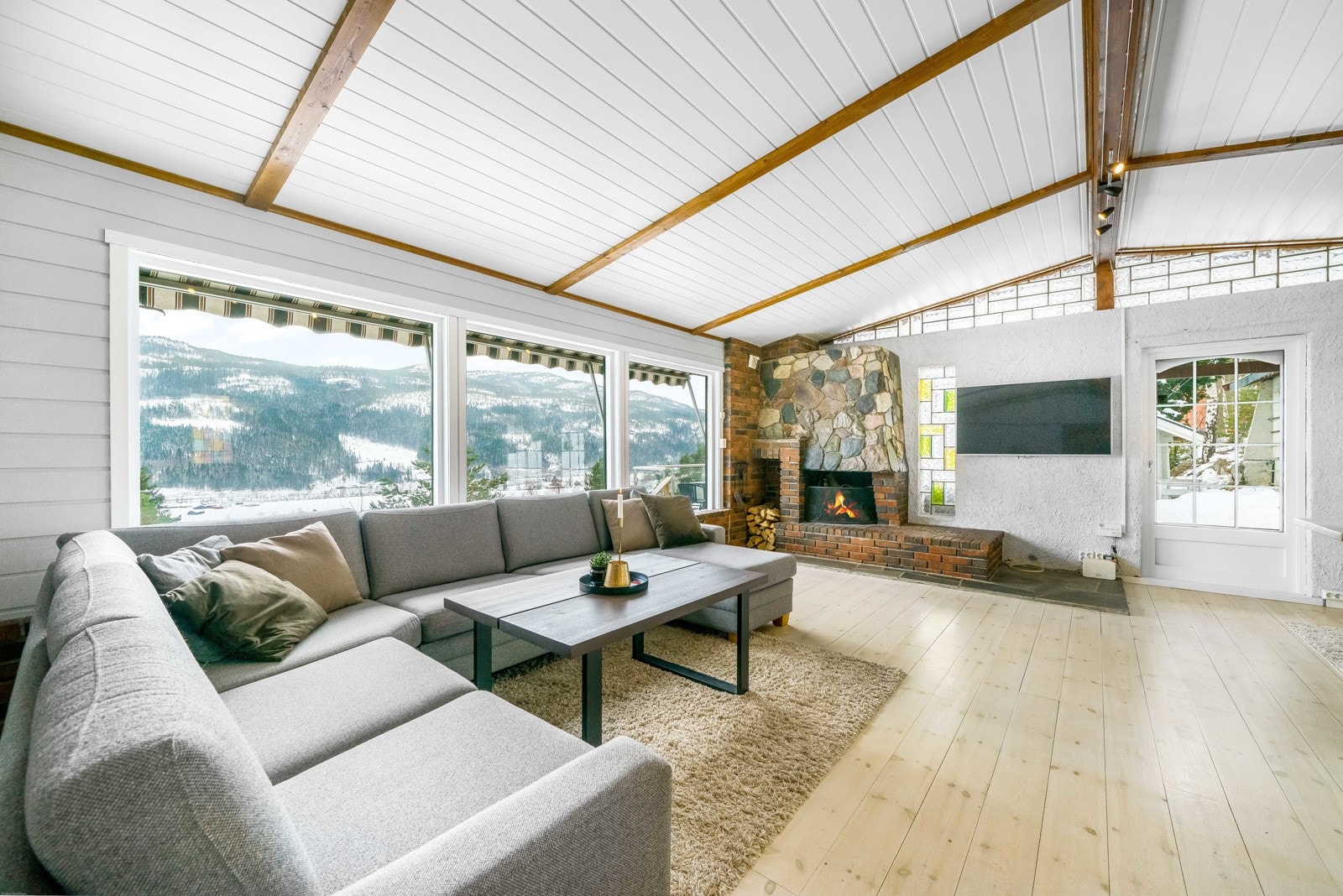 Store vindusflater gir rikelig med naturlig lys til stuen. Galleribilde