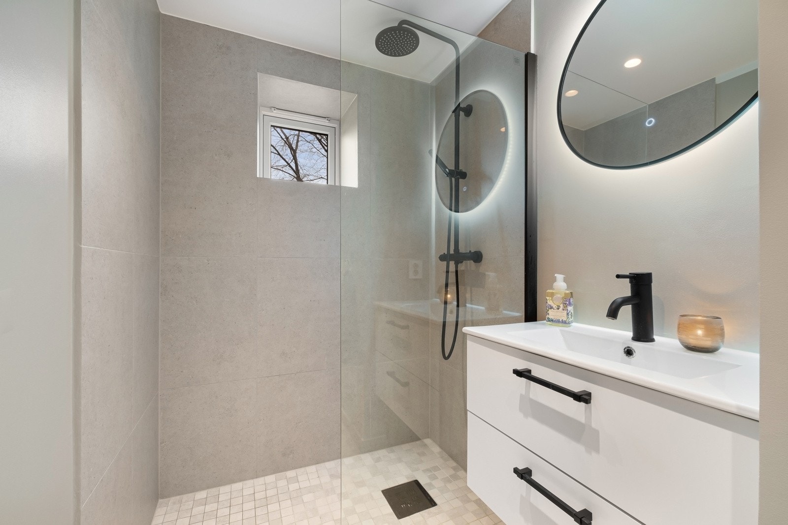 Badet er utstyrt med nedfelt servant, veggmontert toalett, dusjhjørne med glassvegger. Baderomsinnredningen er fra HTH. Galleribilde