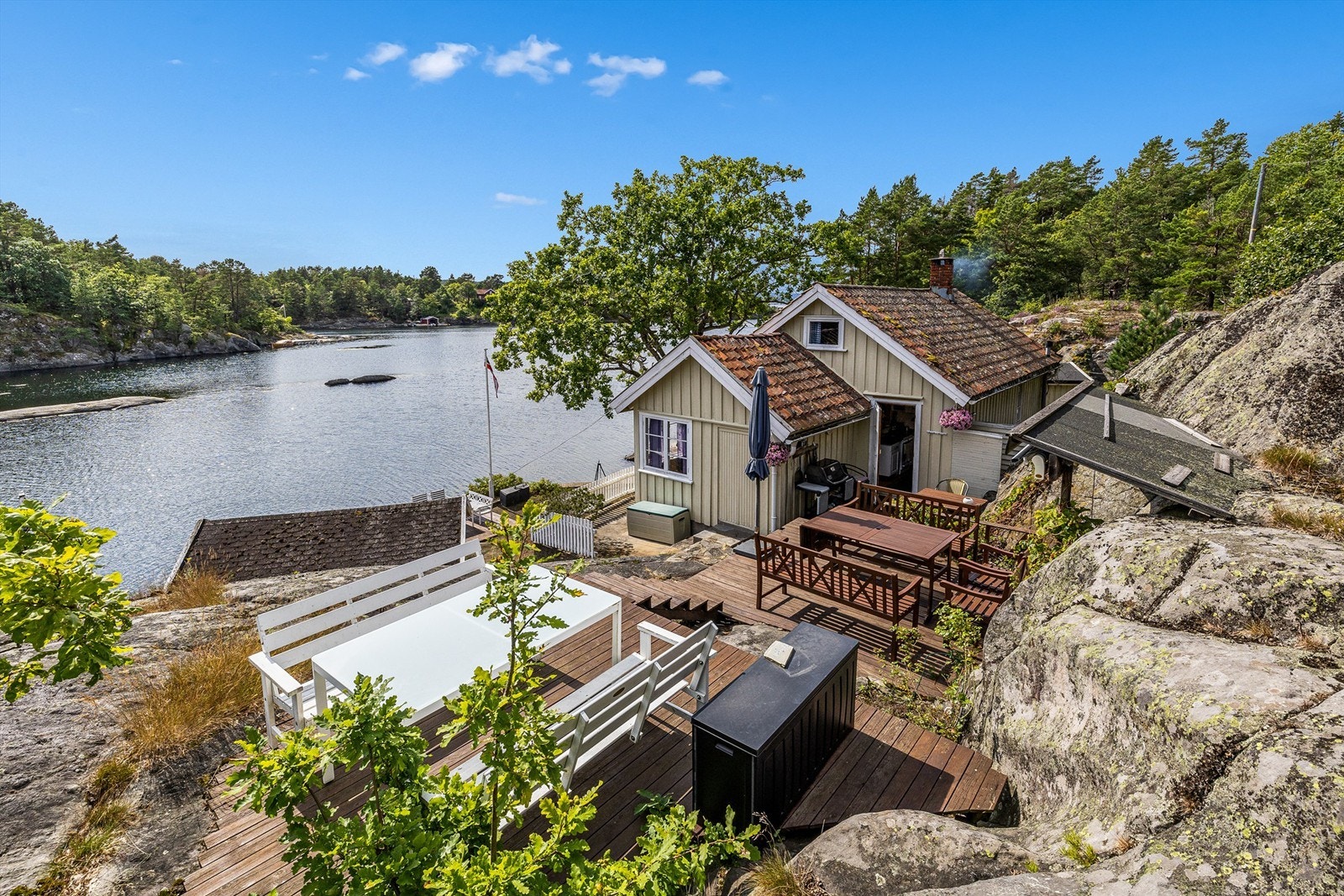 Lykken er å våkne til lyden av bølgeskvulp, ta morgenkaffen på trappen, samle fine folk rundt et bord med god mat og drikke. Galleribilde